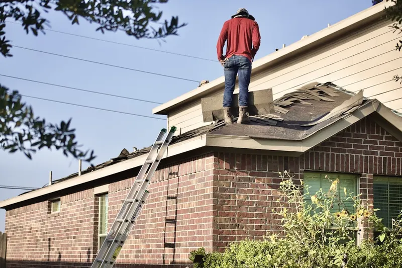 Professional roofer working on a residential roof in Plains
